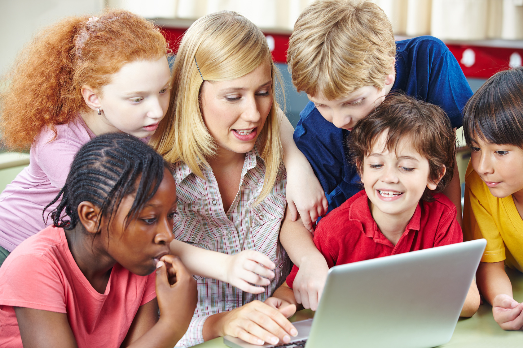 Schüler und Lehrer mit Computer im Internet im Unterricht in der Grundschule